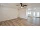 Spacious living room with modern flooring, a ceiling fan and a large window at 8802 W Monterey Way, Phoenix, AZ 85037