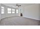 An airy bedroom boasts neutral carpet, multiple windows and a ceiling fan at 9072 W Myrtle Ave, Glendale, AZ 85305