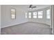 An airy bedroom boasts neutral carpet, multiple windows and a ceiling fan at 9072 W Myrtle Ave, Glendale, AZ 85305