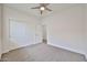 A bedroom featuring a ceiling fan, carpet, and sliding closet doors provides ample storage and comfort at 9072 W Myrtle Ave, Glendale, AZ 85305
