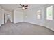 An airy bedroom boasts neutral carpet, multiple windows and a ceiling fan at 9072 W Myrtle Ave, Glendale, AZ 85305