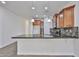 This kitchen features wooden cabinets, tile backsplash, granite countertops and stainless steel appliances at 9072 W Myrtle Ave, Glendale, AZ 85305