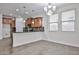 Open kitchen layout with wooden cabinets, backsplash, countertop bar, and tiled floors leading to a dining area at 9072 W Myrtle Ave, Glendale, AZ 85305