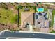 Aerial view showcasing a home with a backyard pool, pergola, and manicured lawns in a well-planned neighborhood at 9157 W Country Club Trl, Peoria, AZ 85383