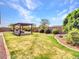 Beautifully landscaped backyard showcasing a charming pergola-covered area, ideal for outdoor entertaining and relaxation at 9157 W Country Club Trl, Peoria, AZ 85383