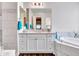 Bright bathroom with double sinks, marble countertops, and large mirror at 9157 W Country Club Trl, Peoria, AZ 85383