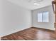 Minimalist bedroom with light walls, wood floors, a ceiling fan and a window bringing in natural light at 9157 W Country Club Trl, Peoria, AZ 85383