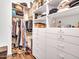 Spacious walk in closet with clothing racks, custom shelving, and wood floors at 9157 W Country Club Trl, Peoria, AZ 85383