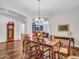 Formal dining room with hardwood floors, decorative table and chairs, and ornate grandfather clock at 9157 W Country Club Trl, Peoria, AZ 85383