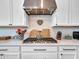 Gourmet kitchen featuring stainless steel appliances, custom cabinetry, and a modern cooktop at 9157 W Country Club Trl, Peoria, AZ 85383
