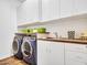 Functional laundry room with modern washer and dryer units and ample storage at 9157 W Country Club Trl, Peoria, AZ 85383