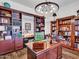 Well-appointed office with custom built-ins, a large desk, and a modern chandelier at 9157 W Country Club Trl, Peoria, AZ 85383