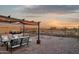 Relaxing backyard retreat with a covered seating area, desert landscape, and stunning sunset views at 10109 E Trailhead Ct, Gold Canyon, AZ 85118