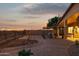 Backyard oasis with brick patio, desert landscaping, and scenic views at sunset at 10109 E Trailhead Ct, Gold Canyon, AZ 85118
