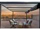 Cozy backyard patio with shaded pergola, comfortable seating, and beautiful desert views at sunset at 10109 E Trailhead Ct, Gold Canyon, AZ 85118