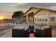 Serene backyard patio with comfortable seating, a covered patio, and desert landscaping at sunset at 10109 E Trailhead Ct, Gold Canyon, AZ 85118