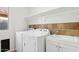 Bright laundry room with a washer, dryer, utility sink, and convenient overhead shelving for storage and organization at 10109 E Trailhead Ct, Gold Canyon, AZ 85118