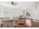 Bright living room features beautiful wood floors, a ceiling fan and comfortable furniture at 10109 E Trailhead Ct, Gold Canyon, AZ 85118