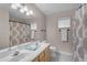 This bathroom features a dual-sink vanity with a shower featuring a decorative curtain rod at 10305 E Plata Ave, Mesa, AZ 85212