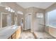 This is a well-lit bathroom offering both a shower and sink vanity with a doorway leading to more spaces at 10305 E Plata Ave, Mesa, AZ 85212