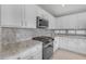 Bright kitchen featuring granite countertops, white cabinetry, and stainless steel appliances at 10305 E Plata Ave, Mesa, AZ 85212