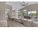 Open-concept living room with high ceilings, large windows overlooking the pool, and seamless flow to the kitchen at 10305 E Plata Ave, Mesa, AZ 85212