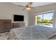 This is a cozy bedroom with neutral decor, a ceiling fan, and a sliding glass door leading to the pool at 10305 E Plata Ave, Mesa, AZ 85212