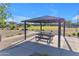 Community park with picnic tables under a shaded structure, offering a place for residents to gather and enjoy the outdoors at 10305 E Plata Ave, Mesa, AZ 85212