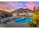 Backyard view of a sparkling blue swimming pool with lounge chairs and patio area at 10305 E Plata Ave, Mesa, AZ 85212
