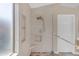 This is a walk-in shower with a built-in seat, stylish tile work, and a grab bar for added safety at 10305 E Plata Ave, Mesa, AZ 85212