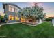 Beautiful backyard showcasing a manicured lawn, blooming trees, and an inviting outdoor seating area at 10344 E Trillium Ave, Mesa, AZ 85212