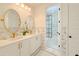 Bathroom featuring dual sinks, oval mirrors, and a tiled shower for a luxurious feel at 10344 E Trillium Ave, Mesa, AZ 85212