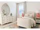 Charming bedroom featuring a decorative mirror, dresser, and bed with soft, neutral tones at 10344 E Trillium Ave, Mesa, AZ 85212