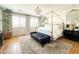 Bright main bedroom with four-poster bed, black bench, natural lighting, and neutral color palette at 10344 E Trillium Ave, Mesa, AZ 85212