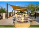 Relaxing fire pit area with seating, BBQ grills, and shade canopies for outdoor community gatherings at 10344 E Trillium Ave, Mesa, AZ 85212