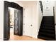 Elegant hallway featuring an ornate, dark wood door frame and staircase with dark treads and white risers at 10344 E Trillium Ave, Mesa, AZ 85212