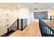 Well-lit upstairs hallway with wood floors, black iron railing, and decorative wall art at 10344 E Trillium Ave, Mesa, AZ 85212