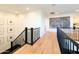 Upstairs hallway showcasing hardwood floors, a black banister, and a gallery wall leading to other rooms at 10344 E Trillium Ave, Mesa, AZ 85212