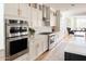 Stylish kitchen with stainless steel appliances, white cabinetry, and a view to the dining room at 10344 E Trillium Ave, Mesa, AZ 85212