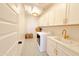 Convenient laundry room featuring a washing machine, dryer, utility sink, and ample storage space at 10344 E Trillium Ave, Mesa, AZ 85212