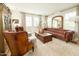 Elegant living room with leather seating, shutters, wood floors, and decorative furnishings at 10344 E Trillium Ave, Mesa, AZ 85212