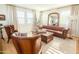Charming living room featuring a leather sofa set, plantation shutters, and hardwood floors at 10344 E Trillium Ave, Mesa, AZ 85212