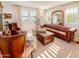 Cozy living room featuring hardwood floors, plantation shutters, and comfortable seating, flooded with natural light at 10344 E Trillium Ave, Mesa, AZ 85212