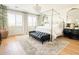 Light, airy main bedroom boasts a four-poster bed, plantation shutters, and beautiful area rug at 10344 E Trillium Ave, Mesa, AZ 85212