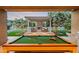 Outdoor living area with pool table, fireplace, pergola, manicured lawn, and lush landscaping at 10344 E Trillium Ave, Mesa, AZ 85212