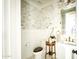 Chic powder room with marble accent wall, pedestal sink, and decorative gold fixtures at 10344 E Trillium Ave, Mesa, AZ 85212