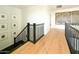 Modern staircase featuring wood floors, black metal railings, and decorative wall art at 10344 E Trillium Ave, Mesa, AZ 85212