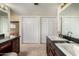 Bright bathroom with dual sinks, dark cabinets, granite countertop, and two large closets at 1062 E Watson Dr, Tempe, AZ 85283