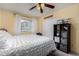 Cozy bedroom with a ceiling fan, closet, and a bed with white bedding and yellow walls at 1062 E Watson Dr, Tempe, AZ 85283