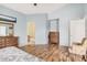 Spacious bedroom with wood floors, light blue walls, and a view to the ensuite bathroom at 10755 W Mountain View Dr, Avondale, AZ 85323